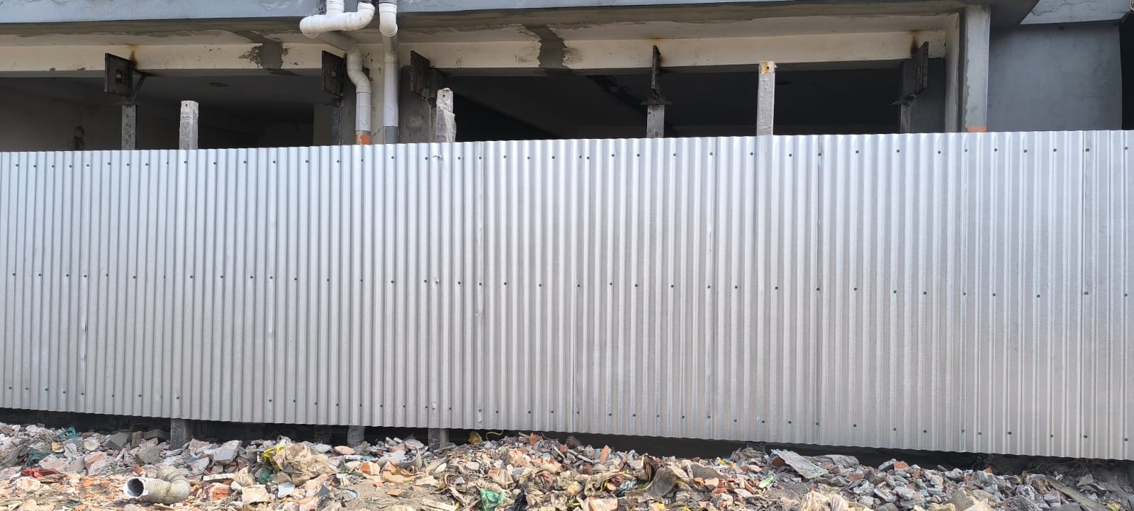 তিন তলা ভবনের সামনে টিনের বেড়া, প্রবেশে বাধা